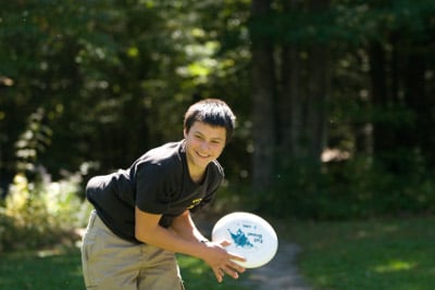 middle schooler throwing frisbee